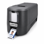 Polaroid instant printer printing a name badge showing a portrait and the name alex lim (product manager).
