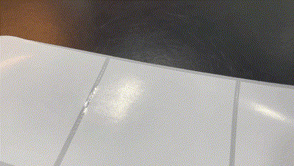 Close-up of white ceramic floor tiles with visible grout lines and a dark background at the top edge.