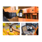 Warehouse worker in a yellow glove holds a handheld barcode scanner to scan items on shelving or equipment behindtrim