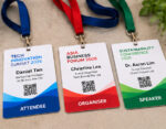 Three conference name badges on lanyards Attendee Daniel Tan for Tech Innovation Summit 2026 Organizer Christine Lee for Asia Business Forum 2026 and Speaker Dr Aaron Lim for Sustainability Conference 2026